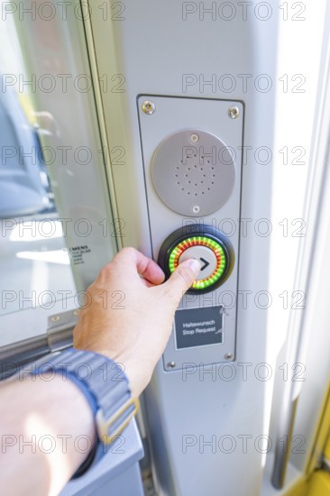 Hand presses stop button on a modern vehicle door, battery Electric train powered by green electricity, Siemens Mireo Plus B, Freudenstadt, Germany