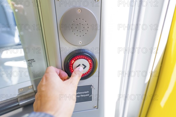 Hand operates a red illuminated stop button on a door in the vehicle, battery Electric train with green electricity, Siemens Mireo Plus B, Freudenstadt, Germany