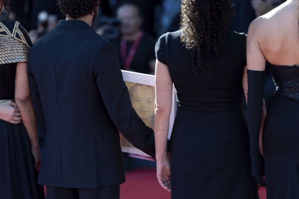 Venice, Italy - 3 September 2025: Motaz Malhees with a portrait of five-year-old Palestinian girl Hind Rajab, who was killed by the Israeli army in the Gaza Strip in January 2024, during the red carpet of - The Voice Of Hind Rajab - during the 82nd Venice International Film Festival