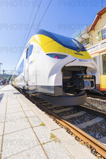 Yellow and white train on the tracks, slight angle of view from below at the station, battery Electric train with green electricity, Siemens Mireo Plus B, Freudenstadt, Germany