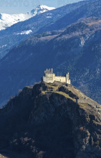 The ruins of Tourbillon Castle sit enthroned on a hill in front of the snow-capped mountains of the Valais Alps, Sion, Valais, Switzerland
