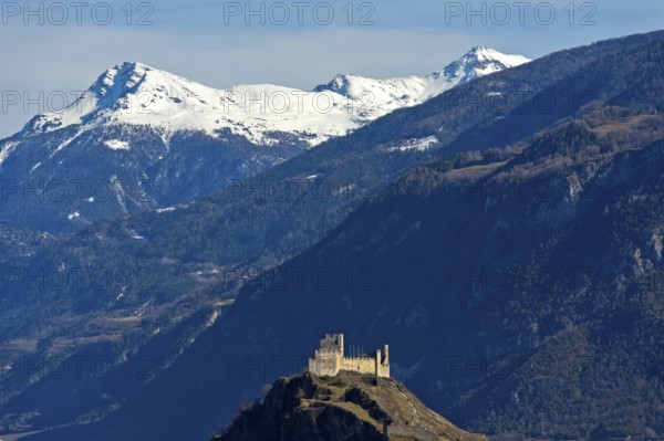 The ruins of Tourbillon Castle sit enthroned on a hill in front of the snow-capped mountains of the Valais Alps, Sion, Valais, Switzerland