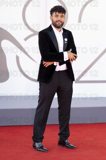 Venice, Italy - 3 September 2025: Amine Bouhafa wears a sticker in the colours of the Palestine flag and a sticker with the inscription - enough - on his jacket during the red carpet of - The Voice Of Hind Rajab - during the 82nd Venice International Film Festival