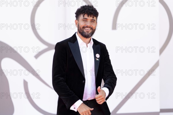 Venice, Italy - 3 September 2025: Amine Bouhafa wears a sticker in the colours of the Palestine flag and a sticker with the inscription - enough - on his jacket during the red carpet of - The Voice Of Hind Rajab - during the 82nd Venice International Film Festival
