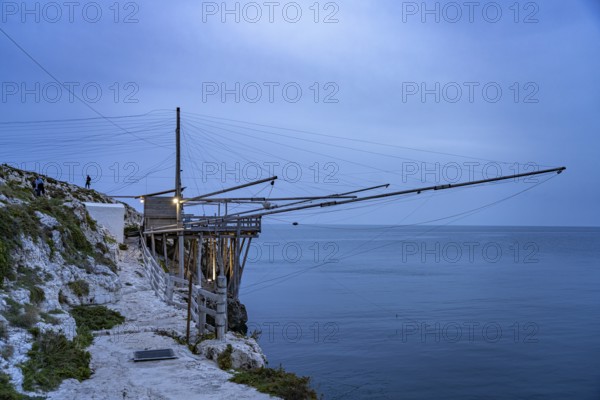 Historic pile dwelling of the fishermen Trabucco on the coast of Vieste at dusk, Gargano, Apulia, Italy