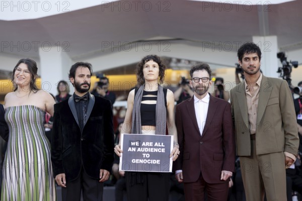 Venice, Italy - 1 September 2025: Charlie Kaufman, Eva H.D., Josef Akiki, Emily McCann Lesser, Avan Jogia and Isabelle Deluce with a sign reading - We are all an audience to Genocide - during the red carpet of - The Smashing Machine - during the 82nd Venice International Film Festival