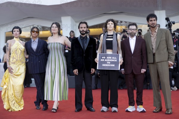 Venice, Italy - 1 September 2025: Charlie Kaufman, Eva H.D., Josef Akiki, Emily McCann Lesser, Halsey, Avan Jogia and Isabelle Deluce with a sign reading - We are all an audience to Genocide - during the Red Carpet of - The Smashing Machine - during the 82nd Venice International Film Festival