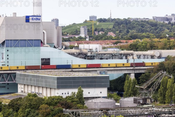 Goods train travelling on the Schusterbahn, Münster viaduct with EnBW Energie Baden-Württemberg combined heat and power plant. Stuttgart, Baden-Württemberg, Germany