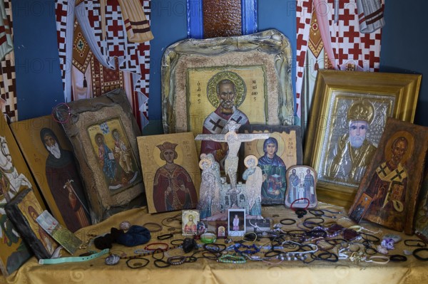 Table full of orthodox icons of various saints in an interior, Agios Nikolaos Chapel, harbour, Kolymbia, Rhodes, Dodecanese, Greek Islands, Greece