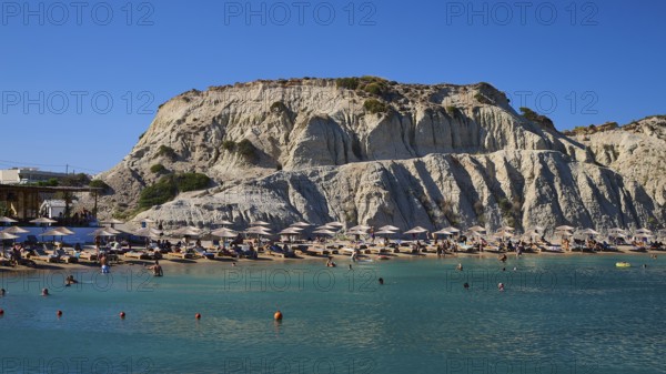 Lively beach against a rocky backdrop with bathing facilities and numerous parasols, Limanaki Beach, sandstone cliffs, Kolymbia, Rhodes, Dodecanese, Greek Islands, Greece
