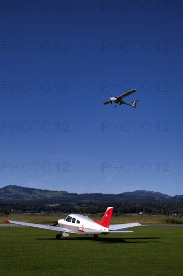Pipistrel Velis Club with aircraft registration HB-NPP taking off over Piper Archer II HB-PPY on the ground, Wangen-Lachen airfield, LSPV, Canton Schwyz, Switzerland