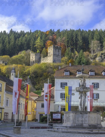 Main square with fountain behind castle ruins, Friesach, Carinthia, Austria