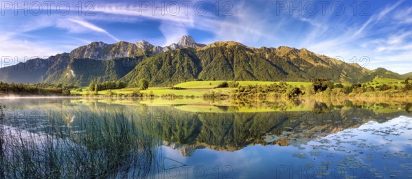 Stockhorn range with the Stockhorn mountain reflected in the Uebeschi lake in the morning light, Gürbetal, Canton of Bern, Switzerland