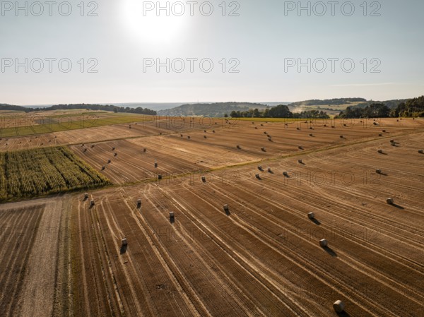 Spacious fields with straw bales under a bright sky, quiet and summery, Gechingen, district of Calw, Germany