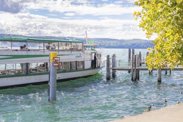 Boat approaching a jetty on a lake on a sunny day, Lake Constance, Germany