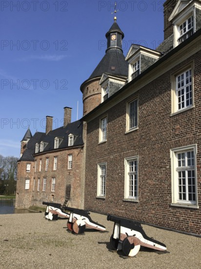 View of small cannons in front of right part of outer bailey building, left in background part of main castle building and top of keep tower, moated castle moated castle Anholt, Isselburg, North Rhine-Westphalia, Germany