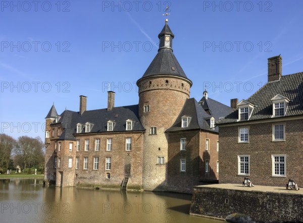 View over moat of moated castle Anholt to main castle with keep tower on the left, part of outer bailey on the right, moated castle Anholt, Isselburg, North Rhine-Westphalia, Germany