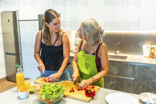 Mother and daughter preparing a healthy vegetable salad together in a modern kitchen, promoting family bonding and healthy eating habits