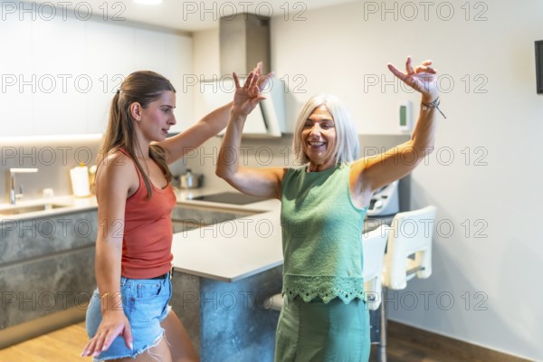 Energetic mother and daughter enjoying a lively dance in a modern kitchen, showcasing family bonding and happiness through movement