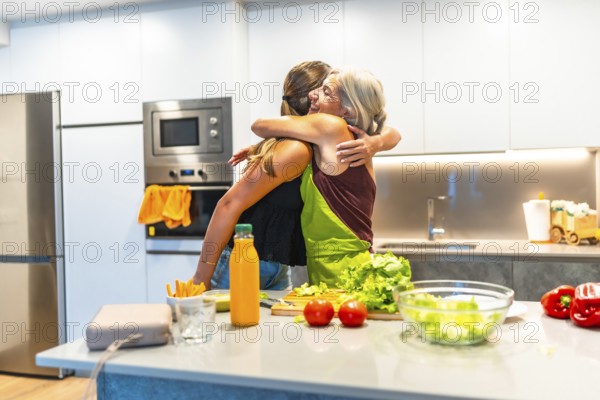 Two women embracing in a kitchen while preparing a vibrant, healthy meal filled with fresh vegetables and love for each other