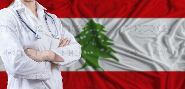 Doctor with crossed arms on Lebanon flag. Lebanese health and care concept. Female doctor on Lebanon flag