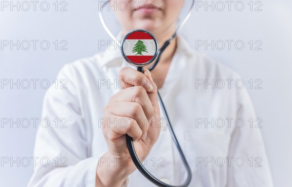 Female doctor holding stethoscope with Lebanon flag. National health system of Lebanon