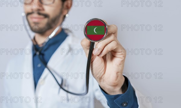 Doctor holding stethoscope with Maldives flag. Maldives health and care concept, Maldives flag on stethoscope