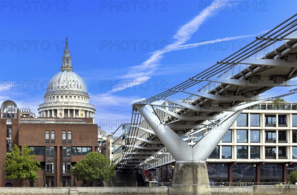 Millennium Bridge in London city financial business center, view from the River Thames