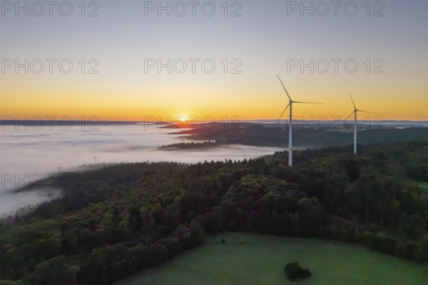 Wind turbines at sunrise over a misty forest landscape, near Schorndorf, Rems-Murr district, Rems-Murr-Kreis, Baden-Württemberg, Germany