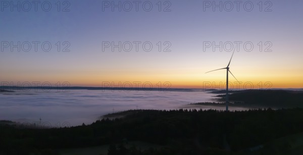 Single wind turbine above a sea of fog against a colourful morning sky, near Schorndorf, Remstal, Rems-Murr-Kreis, Baden-Württemberg, Germany