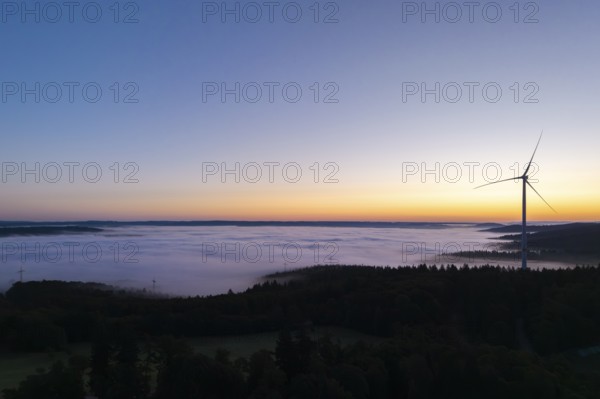 Single wind turbine with fog at sunrise along the horizon, near Schorndorf, Remstal, Rems-Murr-Kreis, Baden-Württemberg, Germany