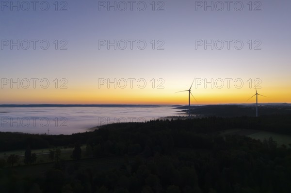 Darker morning sky with wind turbines and fog in the foreground, near Schorndorf, Remstal, Rems-Murr-Kreis, Baden-Württemberg, Germany