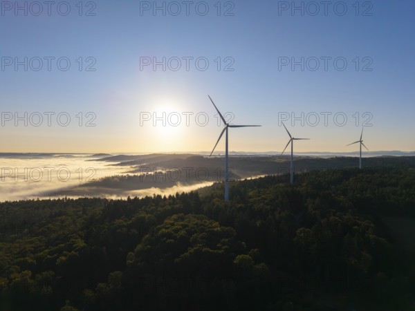 Three wind turbines stand in the early morning light above a misty valley, near Schorndorf, Rems-Murr district, Rems-Murr-Kreis, Baden-Württemberg, Germany