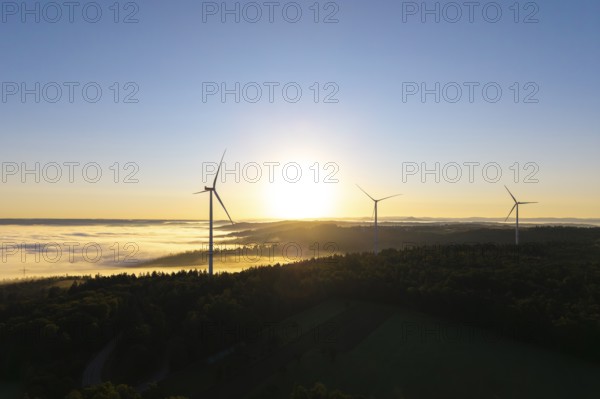 Three wind turbines in the soft morning light over a misty forest landscape, near Schorndorf, Rems-Murr district, Rems-Murr-Kreis, Baden-Württemberg, Germany