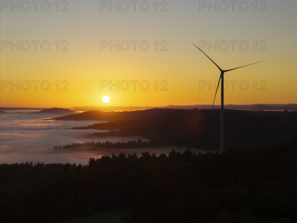 Impressive sunrise with wind turbine over foggy forest, near Schorndorf, Remstal, Rems-Murr-Kreis, Baden-Württemberg, Germany