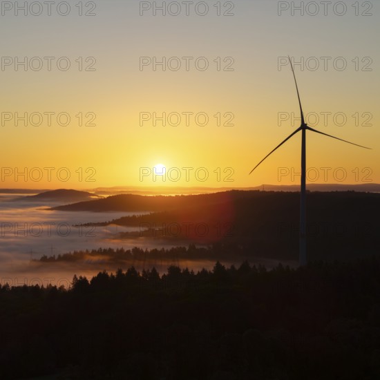 Wind turbine above a misty forest landscape at sunrise, near Schorndorf, Rems-Murr district, Rems-Murr-Kreis, Baden-Württemberg, Germany