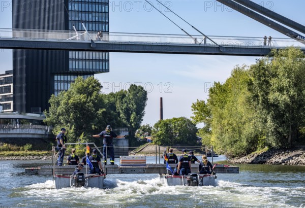 Exercise run of a multi-purpose pontoon on the Rhine, Medienhafen, the skipper gives instructions to the two helmsmen by hand signal, the specialist group for water hazards, in Düsseldorf, the motorised pontoon can be used as a ferry for people or equipment, as a working platform or bridge, during the major exercise FÜLEX25, lasting several days, of the THW, Technisches Hilfswerk, Landesverband North Rhine-Westphalia, over 3500 volunteers from the 127 North Rhine-Westphalia local associations practise many different scenarios over 4 weekends