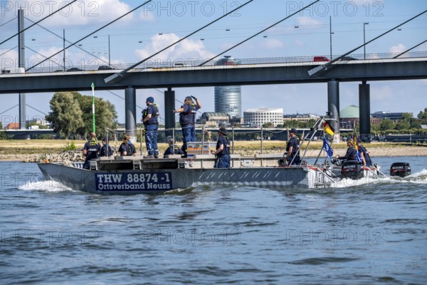 Exercise trip of a multi-purpose pontoon on the Rhine, the skipper gives instructions to the two helmsmen by hand signal, the water hazards specialist group, in Düsseldorf, the motorised pontoon can be used as a ferry for people or equipment, as a work platform or bridge, during the major exercise FÜLEX25, lasting several days, of the THW, Technical Relief Organisation, North Rhine-Westphalia regional association, over 3500 volunteers from the 127 North Rhine-Westphalia local associations practise many different deployment scenarios over 4 weekends