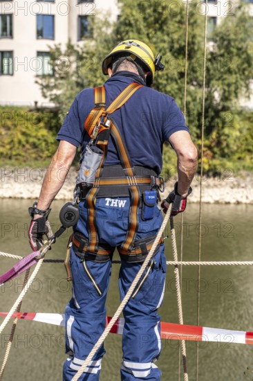 THW emergency services, securing a boat being lowered into the water via a crane, boat crew of the specialist group for water hazards, in Düsseldorf, during the major exercise FÜLEX25, lasting several days, of the THW, Federal Agency for Technical Relief, North Rhine-Westphalia, over 3500 volunteer emergency services from the 127 North Rhine-Westphalia local organisations, practising many different operational scenarios over 4 weekends