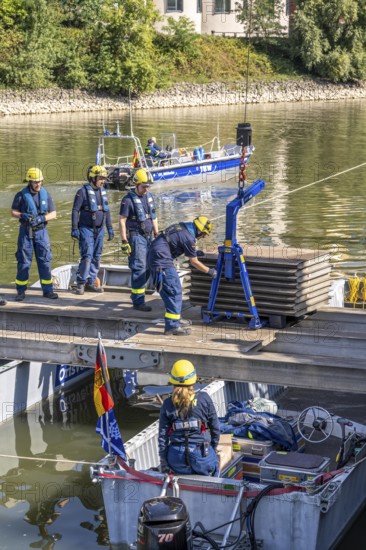Construction of a multi-purpose pontoon, the specialist group for water hazards, in Düsseldorf, the motorised pontoon can be used as a ferry for people or equipment, as a working platform or bridge, during the major exercise FÜLEX25, lasting several days, of the THW, Technisches Hilfswerk, Landesverband North Rhine-Westphalia, over 3500 volunteers from the 127 North Rhine-Westphalia local associations practise many different deployment scenarios over 4 weekends