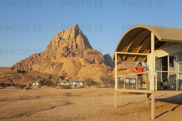 The isolated Spitzkoppe mountain (1728 m) provides a dramatic backdrop for the chalets of the upmarket Spitzkoppen Lodge. Damaraland, Namibia