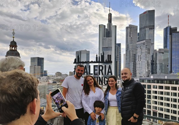 Souvenir photo at the sign of the Gallaria Skylounge with the banking district in the background on Rooftop day, Frankfurt am Main, Hesse, Germany