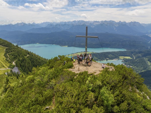 People on the summit with a cross, in the background a wide panoramic view, Herzogstand summit, Walchensee, Schlehdorf, Germany