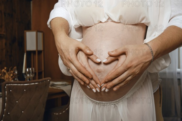 Expecting couple shares loving moment during joyful pregnancy celebration at home
