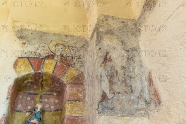 Saint Jean Chapel features ancient wall paintings showcasing religious figures with vibrant colors and intricate details. Champeix village. Puy de Dome. Auvergne Rhone Alpes. France