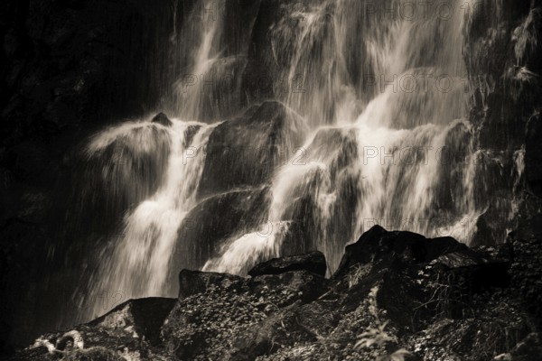 Vaucoux waterfall cascades gracefully over dark rocks, surrounded by lush greenery, Auvergne Volcanoes Regional Park, Puy de Dome., Auvergne-Rhone-Alpes, France