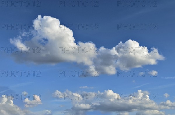 White altocumulus clouds below in the background many cumulus clouds in front of a bright blue sky, international
