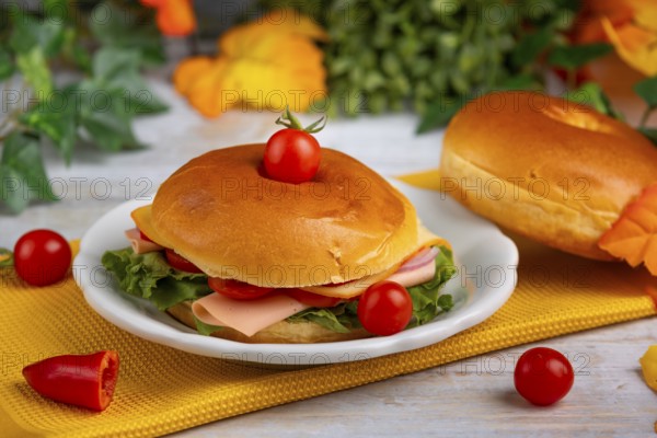An autumnally decorated table with a filled bagel and colourful leaves