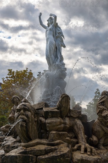 Undine Fountain with dramatic sky in the spa garden Baden, Lower Austria, Austria