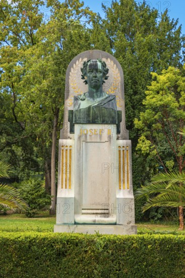 Bust of Joseph II on a monument, embedded in lush greenery and trees, spa garden Baden, Lower Austria, Austria